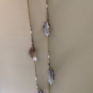 Beautiful gold necklace with beads and feathers